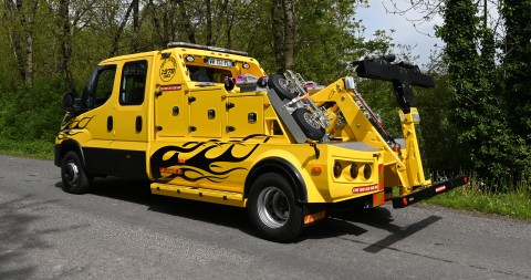 Dépanneuse jaune avec des flammes noires peintes sur les côtés